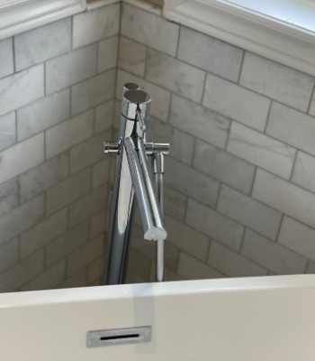 a water tap attached to white washbasin